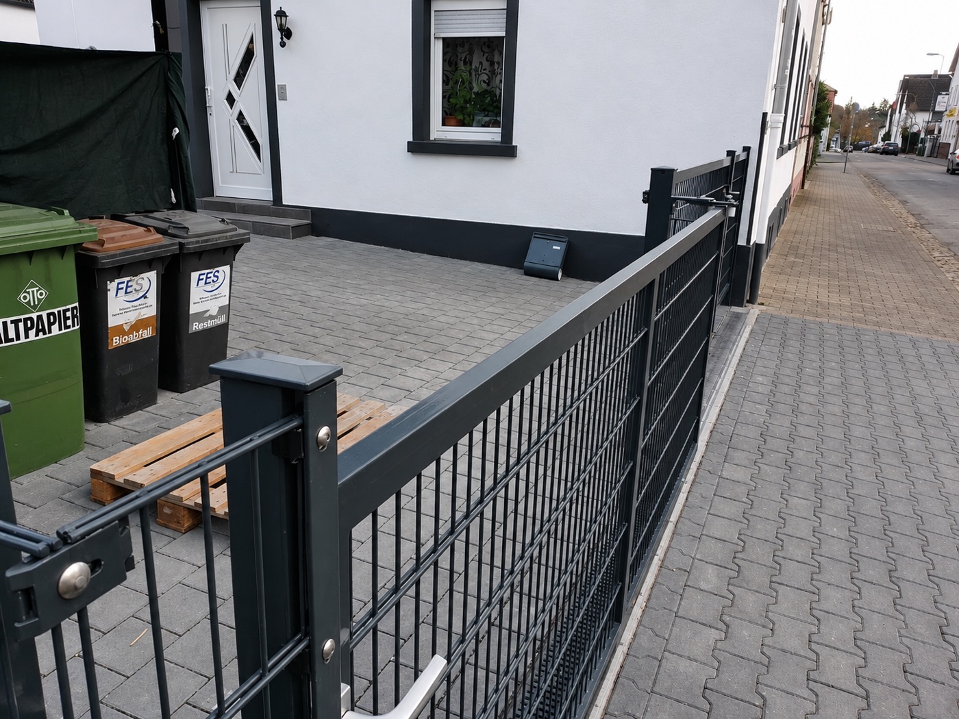 Anthrazitfarbenes Einfahrtstor mit Gitterfüllung vor Wohnhaus – Zaunbauteam Wetterau